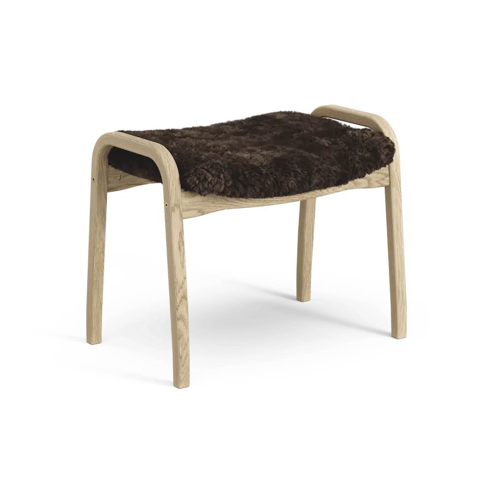 Lamino-Fußhocker | Swedese | Lundia Living mit einem hellen Holzrahmen und einem dunkelbraunen Schaffellsitz für eleganten Sitzkomfort.