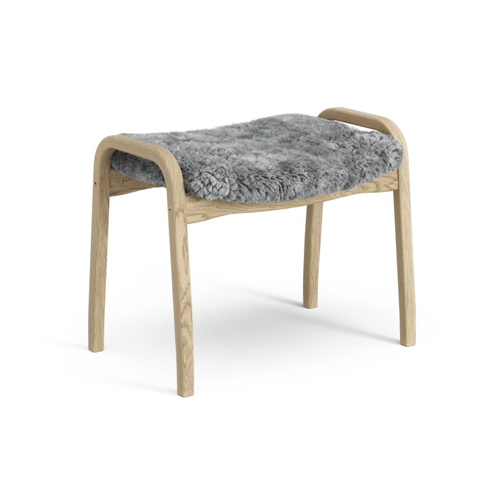 Lamino-Fußhocker | Swedese | Lundia Living: Mit einem hellen Holzrahmen und einem weichen, grauen Schaffellbezug für bequeme Entspannung
