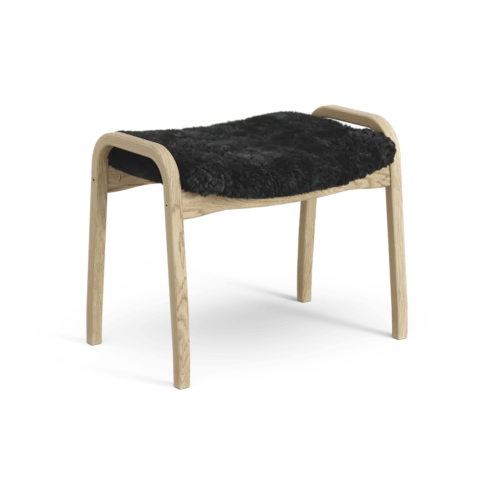 Lamino Fußhocker | Swedese | Lundia Living mit einem leichten Holzrahmen und einem weichen, schwarzen Schaffellsitz für bequemen Sitzkomfort.