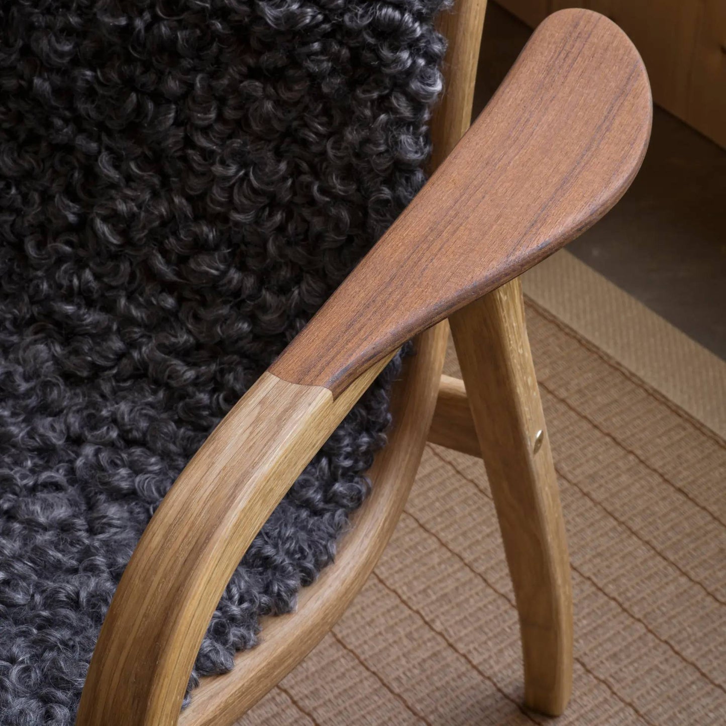 Lamino-Sessel | Swedese | Lundia Living – mit Armlehnen aus Holz und dunkler, lockiger Wolle in einem warmen Interieur
