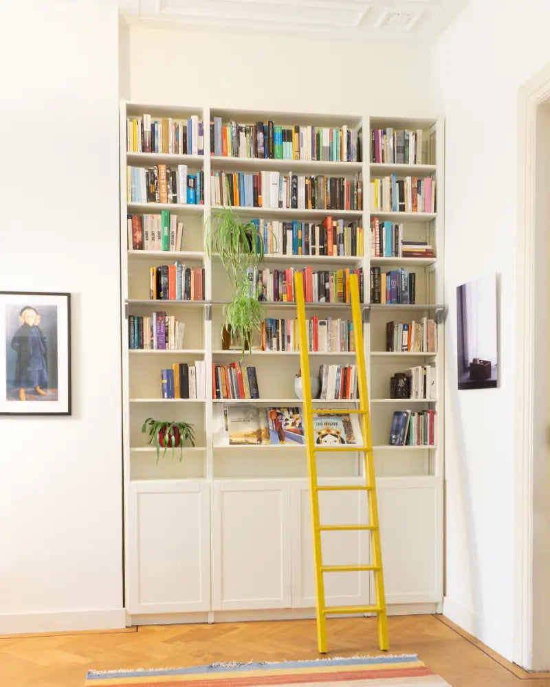 Witte boekenkast op maat van Lundia met gele roltrap